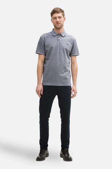 Polo bleu à manches courtes de Tom Tailor, avec un col rayé et porté avec un pantalon noir et des chaussures.