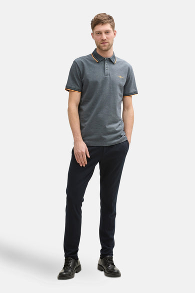 Polo bleu à manches courtes de Tom Tailor, avec col et manches contrastés orange, porté avec pantalon et chaussures noirs.