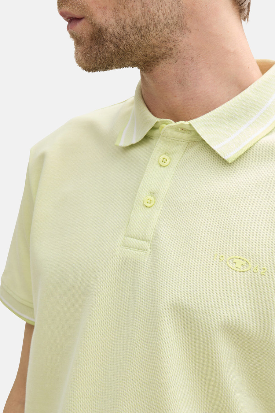 Lichtgroen poloshirt met korte mouwen van Tom Tailor, met witte strepen op de kraag en geborduurd logo.
