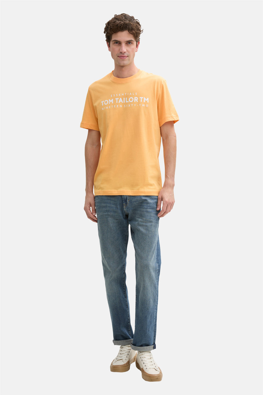 Oranje T-shirt met korte mouwen van Tom Tailor, gedragen met een blauwe spijkerbroek en sneakers.