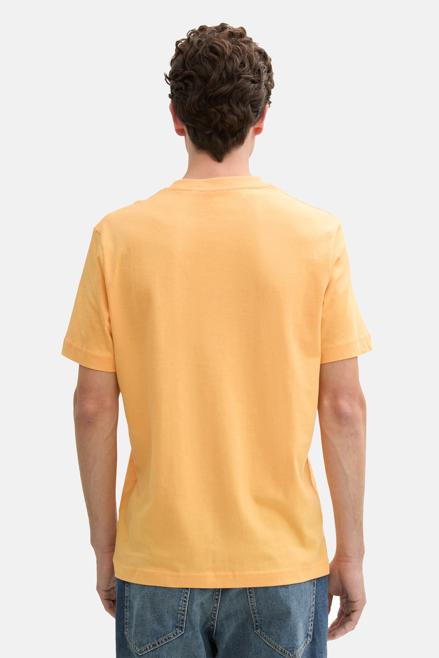 Oranje T-shirt met korte mouwen van Tom Tailor, van achteren gezien, gedragen met een blauwe spijkerbroek.