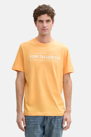 Oranje T-shirt met korte mouwen van Tom Tailor, met witte print, gedragen met een spijkerbroek.