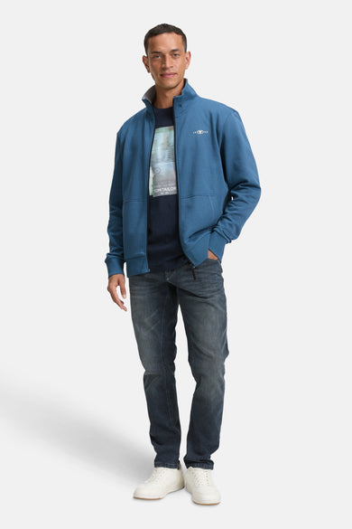 Turquoise gilet van Tom Tailor, gedragen met een bedrukt T-shirt en een donkere jeans.