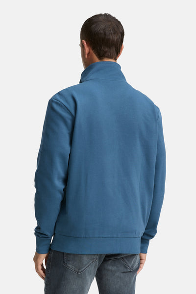 Turquoise gilet van Tom Tailor, achterkant, gedragen met een donkere, uitgewassen spijkerbroek.