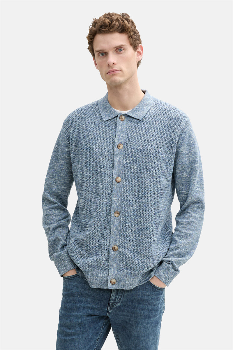 Blauwe Tom Tailor bodywarmer, gebreid met knopen, gedragen met een spijkerbroek.