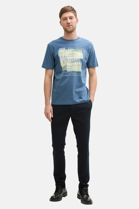Blauw T-shirt met korte mouwen van Tom Tailor, met een grafische print, gedragen met een zwarte broek en schoenen.