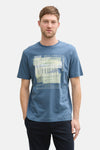 Blauw T-shirt met korte mouwen van Tom Tailor, met een grafische print en tekst, gedragen met een donkere broek.