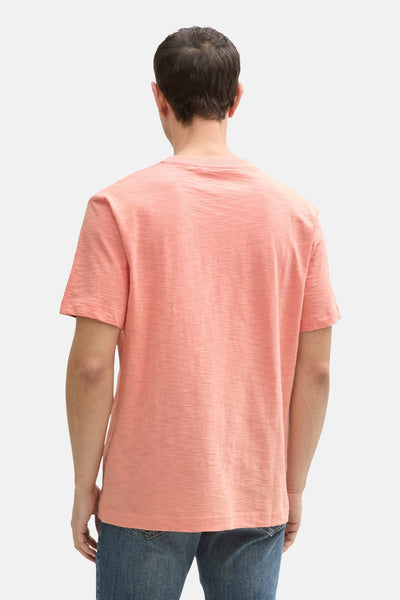 Koraalkleurig T-shirt met korte mouwen van Tom Tailor, met een subtiele textuur en gedragen met een spijkerbroek.