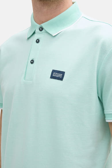 Groen poloshirt met korte mouwen van Tom Tailor, met zwarte knopen en marineblauwe logo.