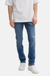 Tom Tailor middellange blauwe rechte jeans, gedragen met een wit T-shirt en witte sneakers.