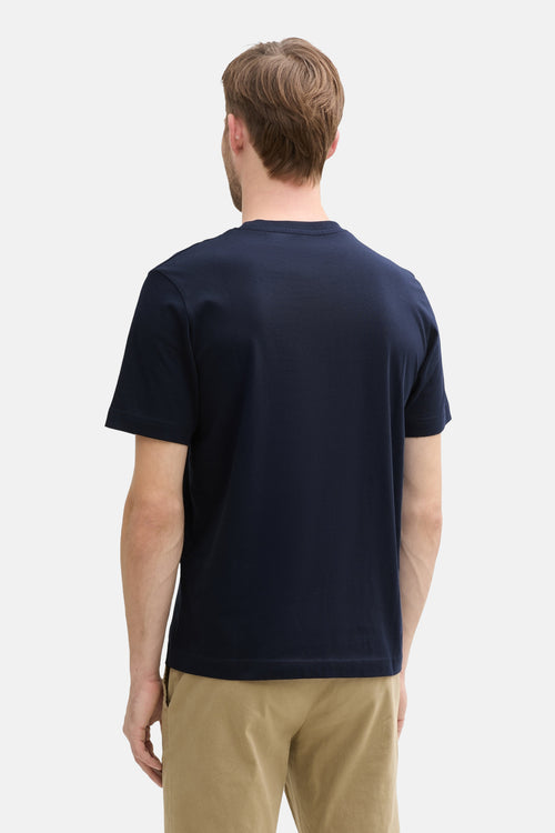 T-shirt bleu à manches courtes de Tom Tailor, porté par un homme vu de dos avec un pantalon beige.