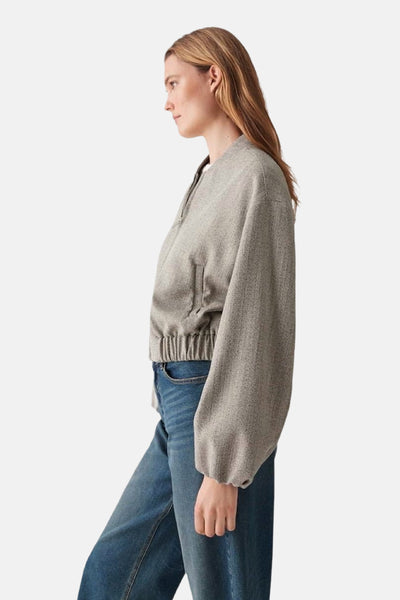 Veste courte beige d'OPUS, avec fermeture éclair, portée avec un jean bleu.