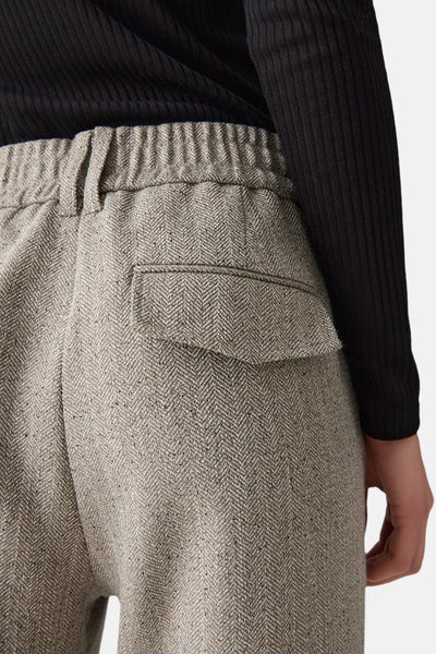 Pantalon de costume beige d'OPUS, à motif chevron, avec une ceinture élastique.