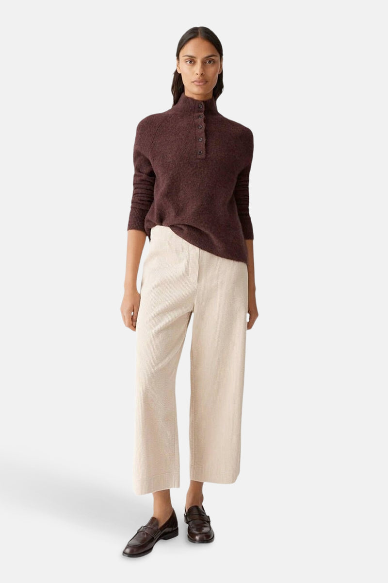 Bruine trui met knopen van OPUS, gedragen met een lichte corduroy broek en loafers.