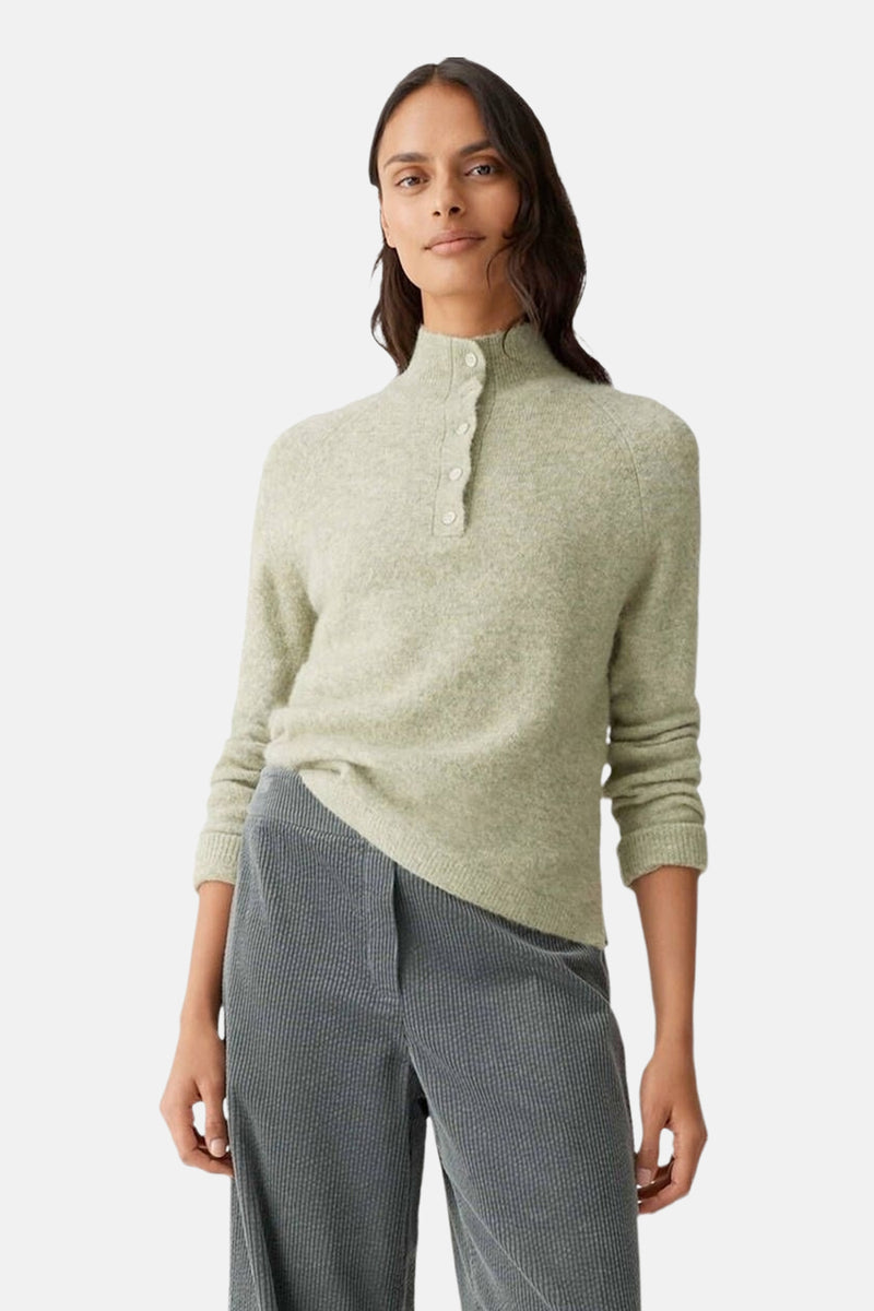 Groene gebreide trui van OPUS, gedragen met een geribbelde grijze broek, van achteren gezien.