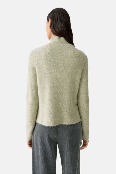 Pull vert en maille d'OPUS, porté avec un pantalon gris côtelé, vu de dos.