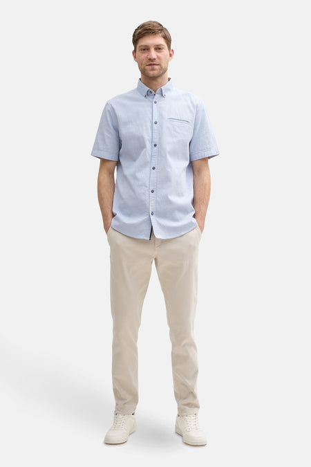 Blauw overhemd met korte mouwen van Tom Tailor, getextureerd, gedragen met een beige broek en witte sneakers.