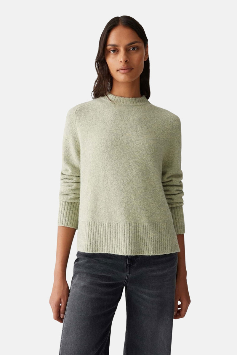 Pull à col rond vert d'OPUS, porté avec un jean sombre à coupe droite.
