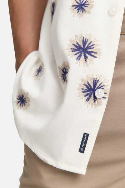 Chemise blanche à fleurs brodées de Tom Tailor, avec bouton et étiquette de la marque.