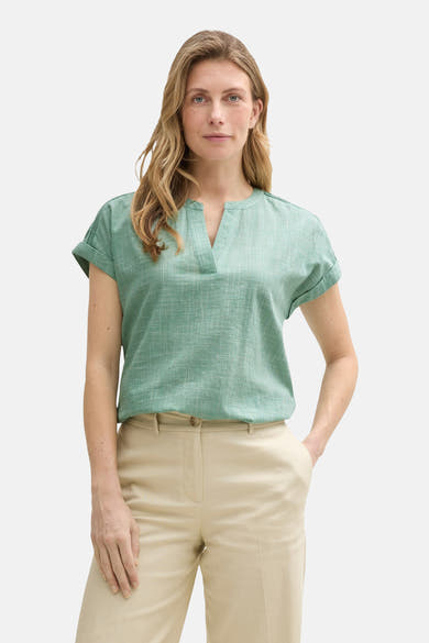 Blouse à manches courtes verte de Tom Tailor, à motif quadrillé, portée avec un pantalon beige uni.