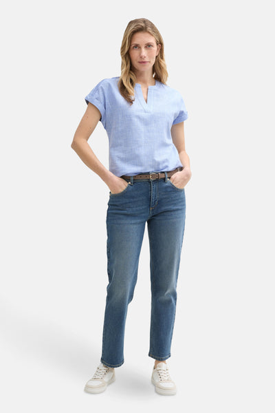 Blouse à manches courtes bleue de Tom Tailor, portée avec un jean taille haute et ceinture marron.