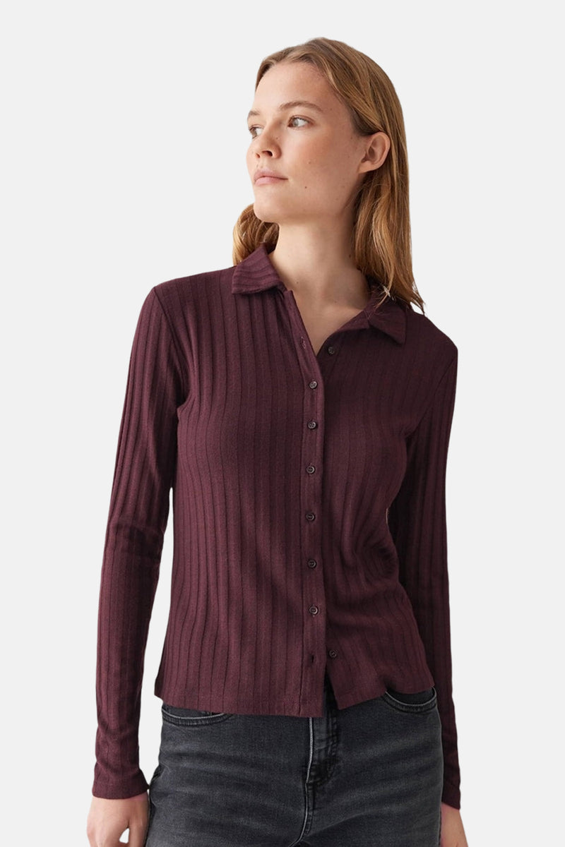 Gilet bordeaux côtelé de OPUS, avec manches longues et boutonné devant, porté avec un jean noir.