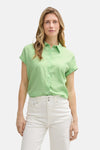 Chemise à manches courtes verte de Tom Tailor, portée avec un pantalon blanc uni.