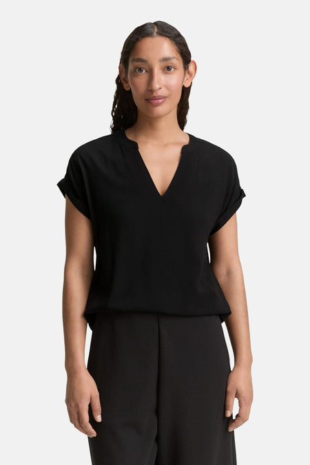 Zwart T-shirt met korte mouwen van Tom Tailor, met V-hals, gedragen met een zwarte broek.