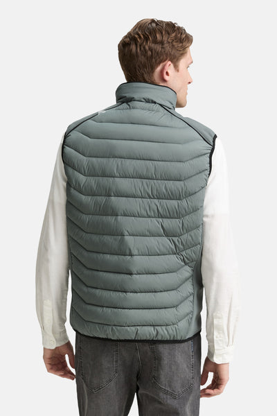 Veste sans manches verte par Tom Tailor, avec un col montant et des rayures horizontales matelassées, portée sur une chemise blanche.