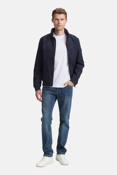Veste courte bleue de Tom Tailor, portée sur un t-shirt blanc et un jean, avec des baskets blanches.