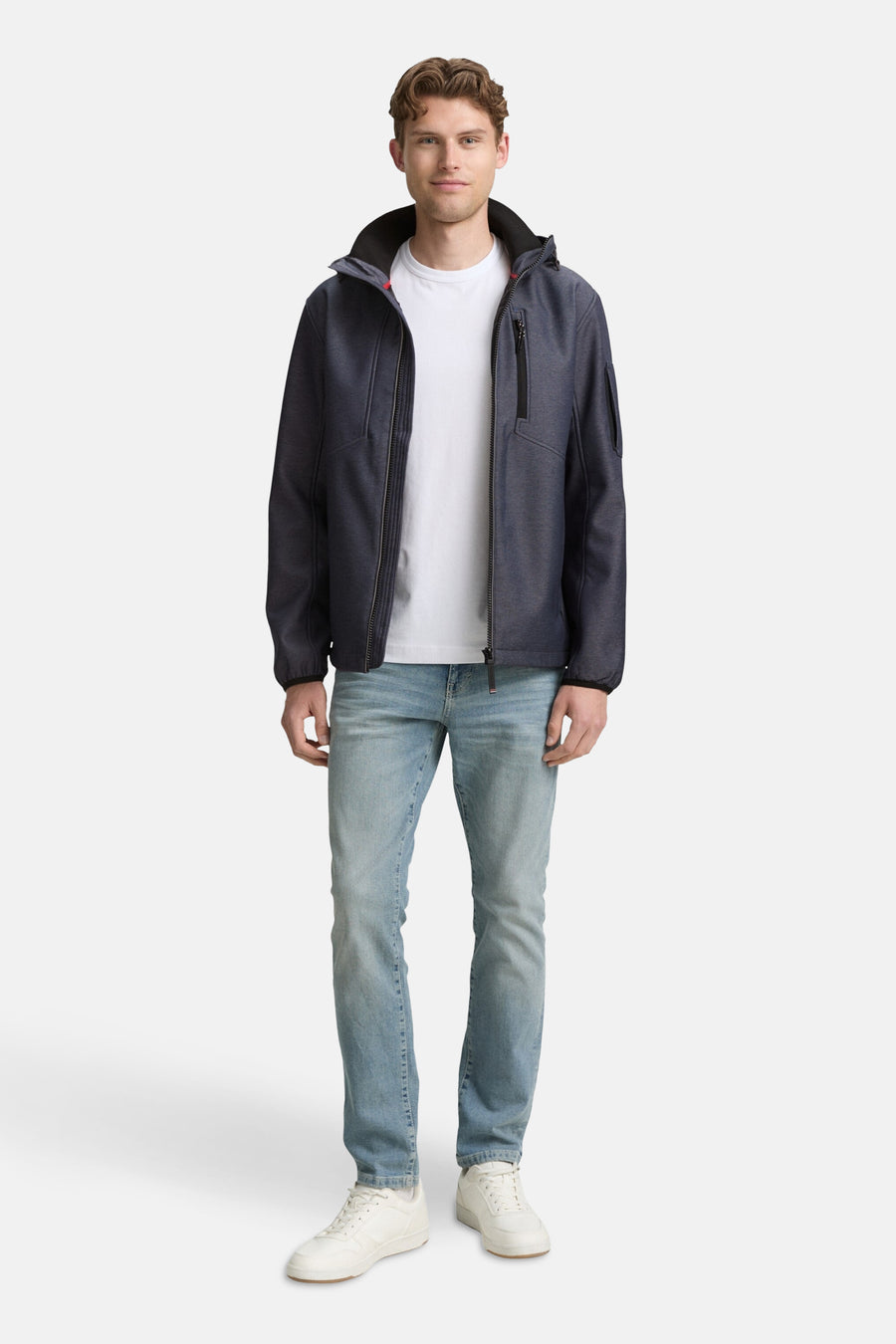 Korte blauwe jas van Tom Tailor, gedragen met een wit T-shirt en een verbleekte spijkerbroek, en witte schoenen.
