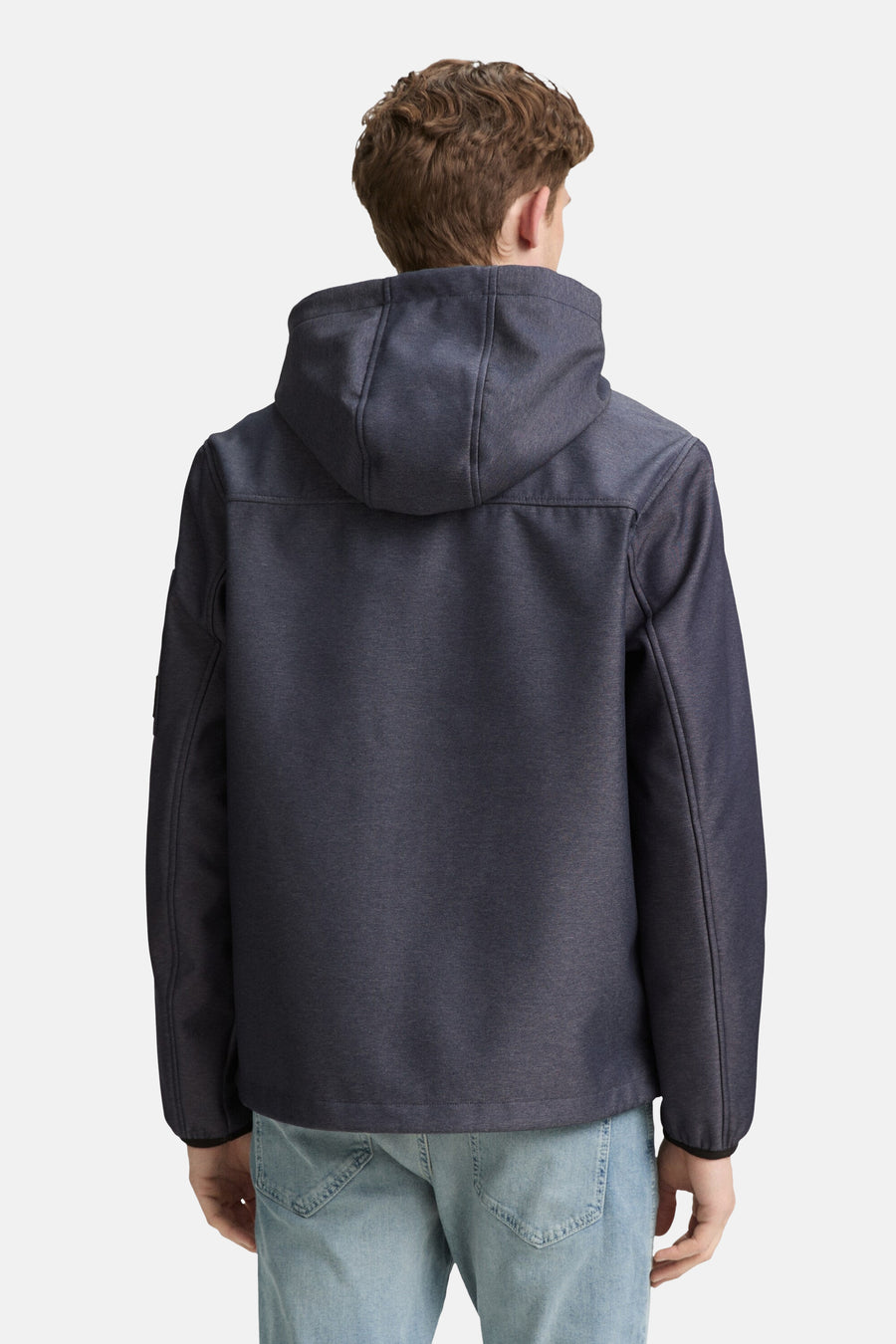 Korte blauwe jas van Tom Tailor met capuchon, achterkant, gedragen met een spijkerbroek.