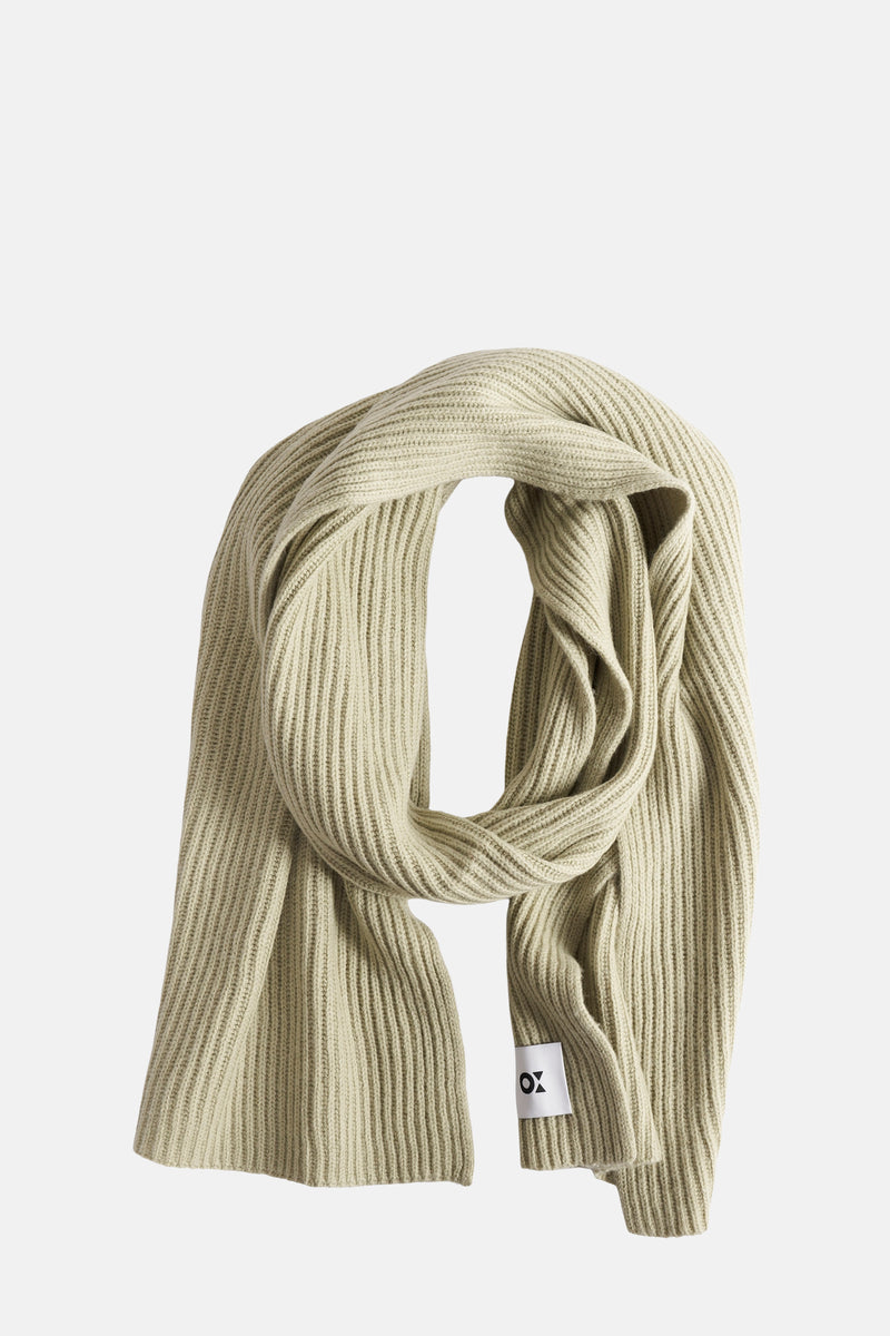 Écharpe verte à côtes by OPUS, nouée avec une étiquette blanche portant un logo noir.