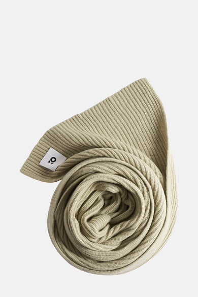 Écharpe vert clair en tricot côtelé par OPUS, enroulée sur elle-même avec étiquette visible.
