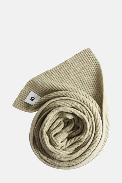 Écharpe vert clair en tricot côtelé par OPUS, enroulée sur elle-même avec étiquette visible.
