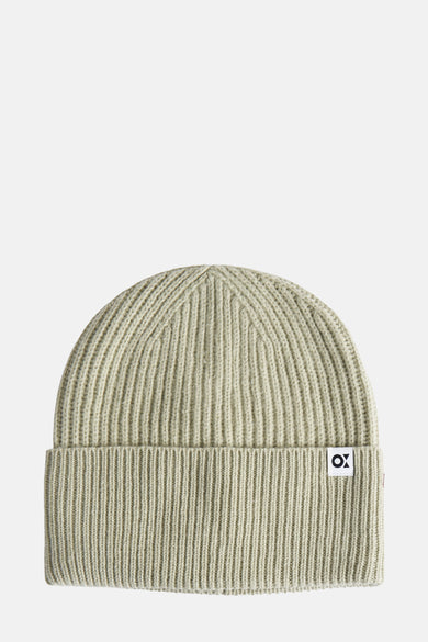Bonnet vert en maille côtelée d'OPUS, avec un petit patch logo blanc sur le bord.