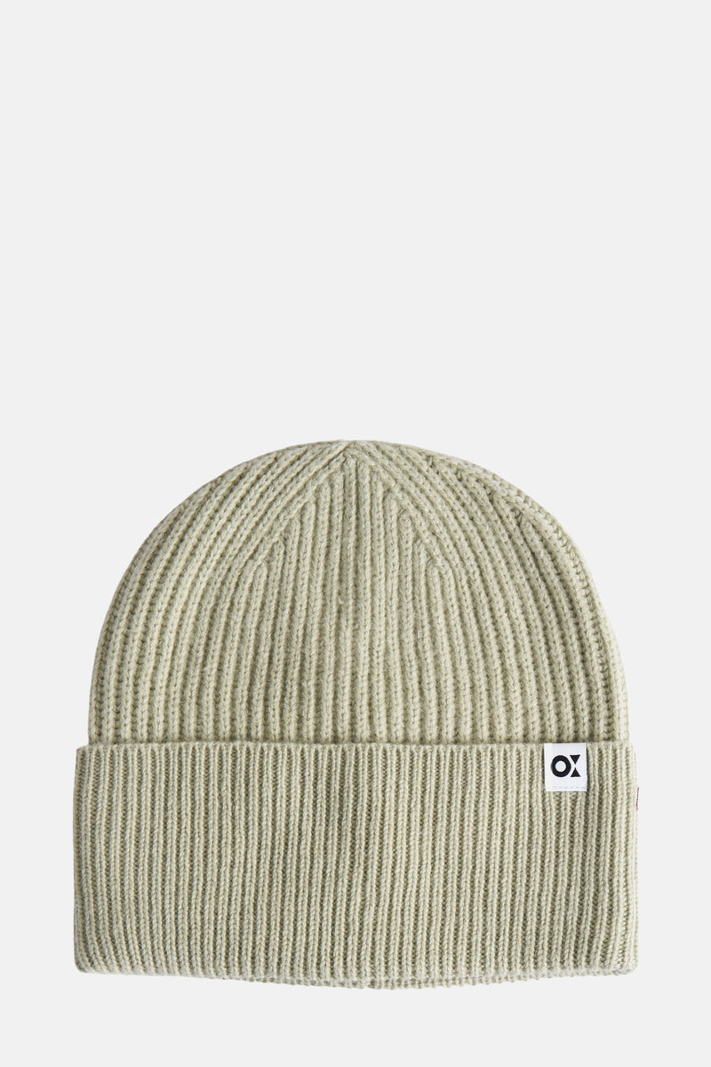 Bonnet vert en maille côtelée d'OPUS, avec un petit patch logo blanc sur le bord.