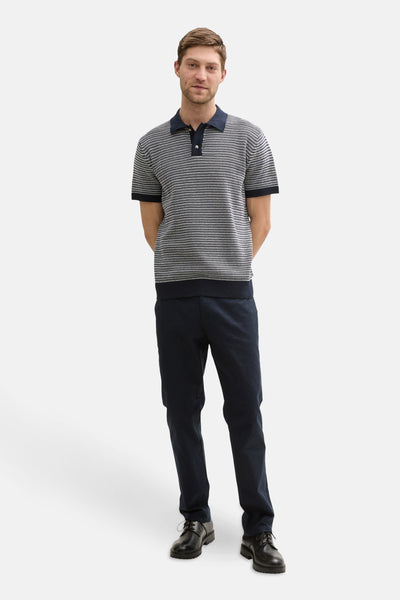 Polo bleu rayé by Tom Tailor, porté avec un pantalon marine et des chaussures noires.