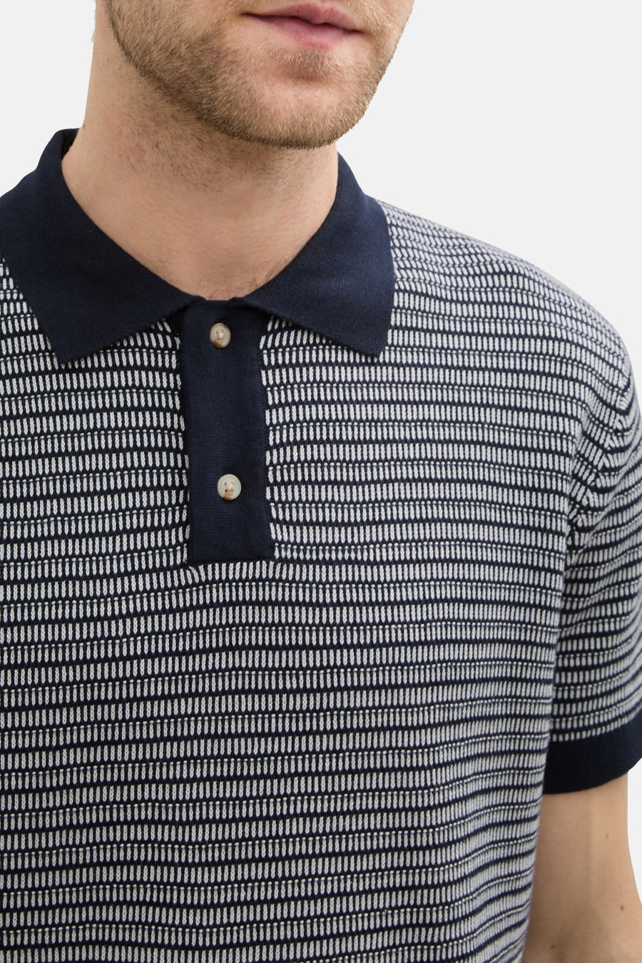 Blauw poloshirt met grafische print van Tom Tailor, met marineblauwe knoopsluiting en lichte knopen.