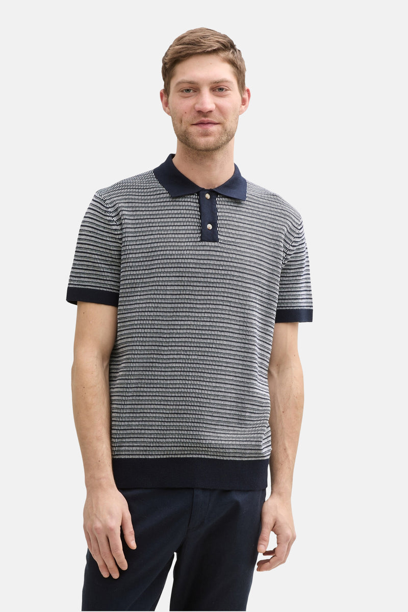 Polo bleu de Tom Tailor, à motif texturé, porté avec un pantalon foncé.
