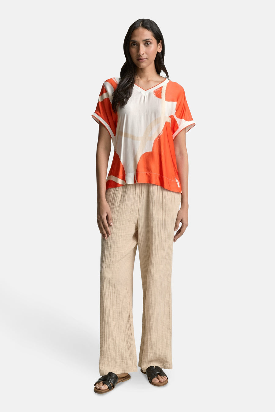 Chemisier à manches courtes multicolore de Tom Tailor, avec un motif graphique et porté avec un pantalon texturé.
