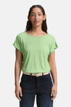 Blouse verte à manches courtes par Tom Tailor, avec ceinture claire et pantalon foncé.
