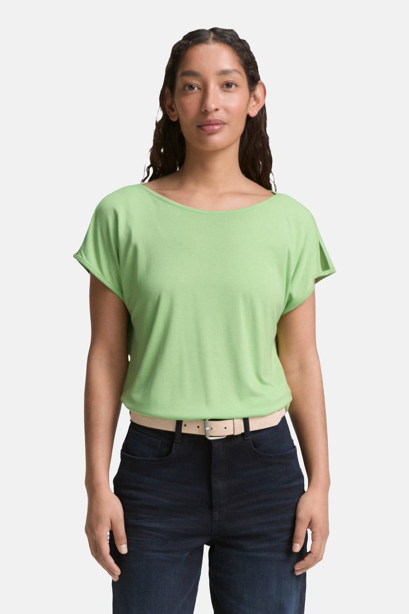 Groene blouse met korte mouwen van Tom Tailor, met een duidelijke riem en donkere broek.
