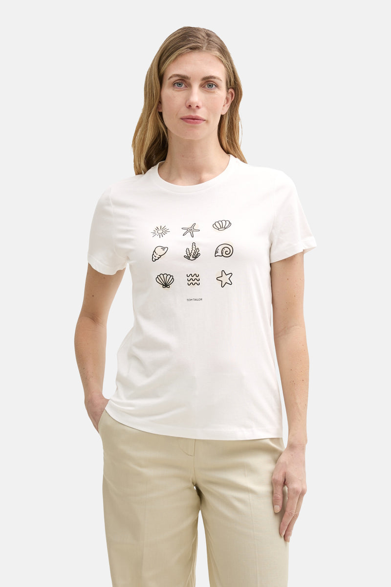 T-shirt blanc à manches courtes de Tom Tailor avec motifs marins décoratifs, porté avec un pantalon beige.