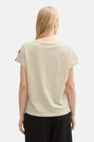 T-shirt beige à manches courtes de Tom Tailor, uni, porté avec un pantalon noir.