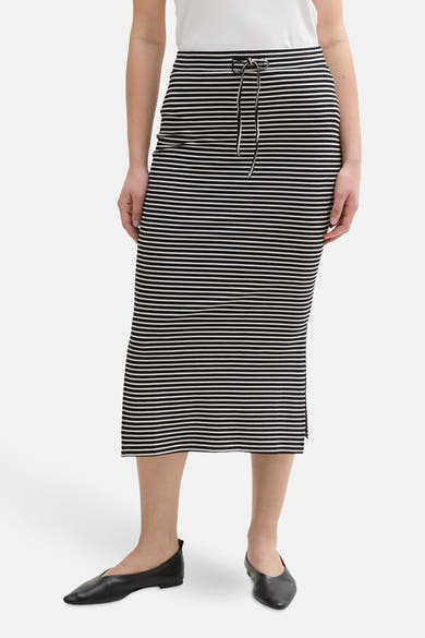 Zwarte gestreepte rok van Tom Tailor, midi-lengte met trekkoord in de taille en zwarte platte schoenen.