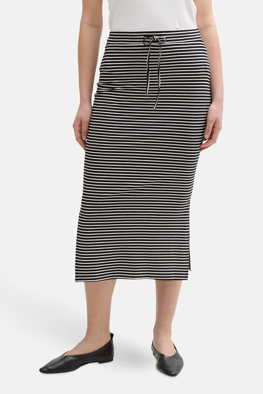 Zwarte gestreepte rok van Tom Tailor, midi-lengte met trekkoord in de taille en zwarte platte schoenen.