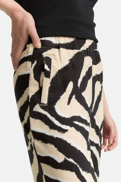 Pantalon multicolore de Tom Tailor, avec motif zébré beige et noir, poche latérale et personne portant un haut noir.