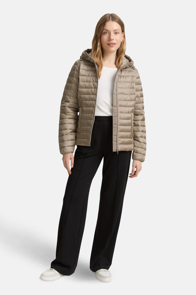Veste courte beige de Tom Tailor, portée avec un T-shirt blanc et un pantalon noir ample.