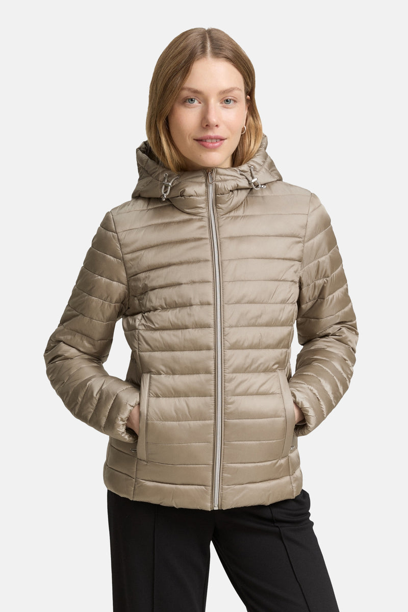 Veste courte beige de Tom Tailor, matelassée avec capuche, portée avec un pantalon noir.